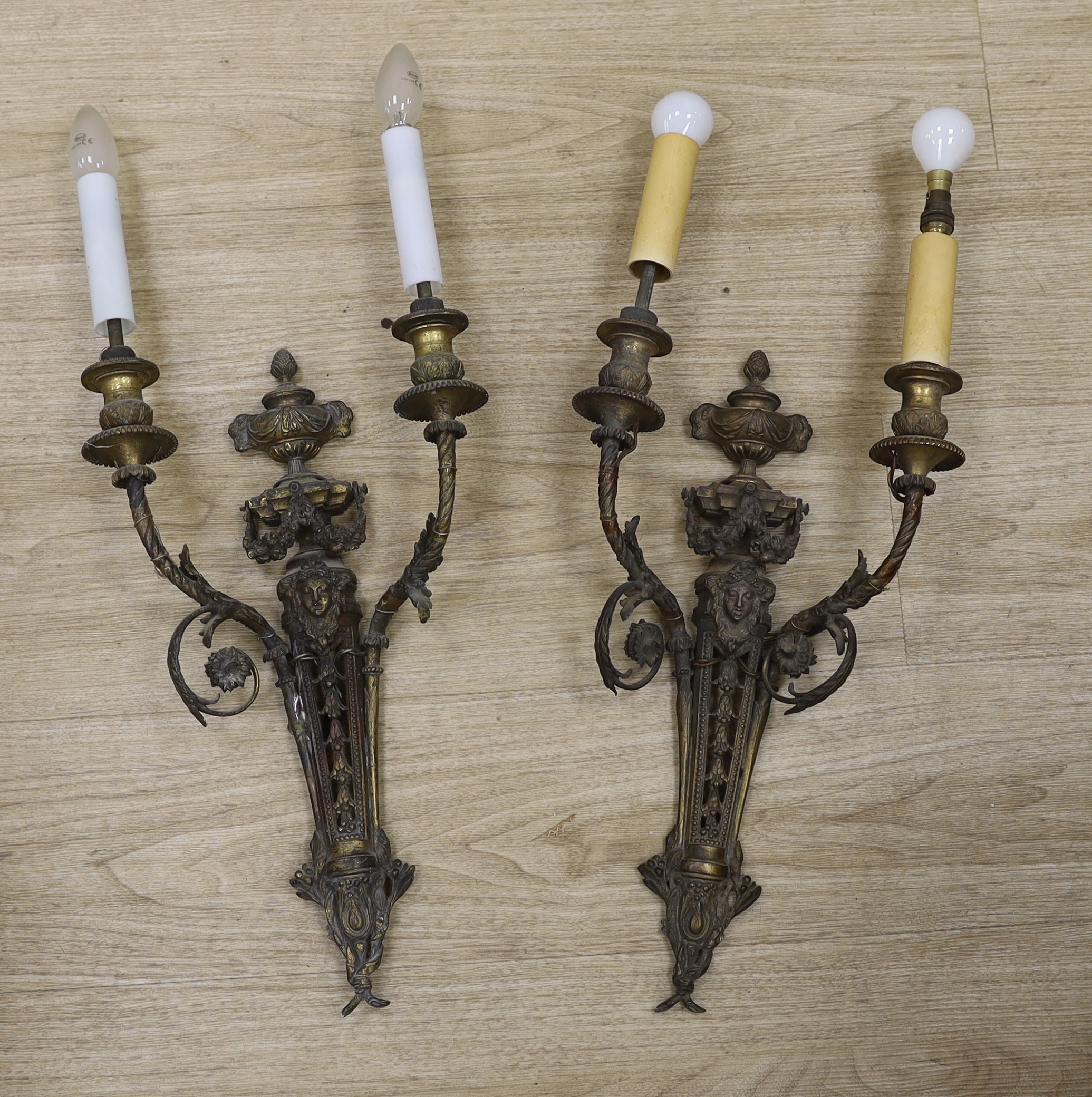 A pair of Louis XVI style cast brass two branch wall lights, 60cm high including fittings. Condition- fair to good, grubby, in need of rewiring